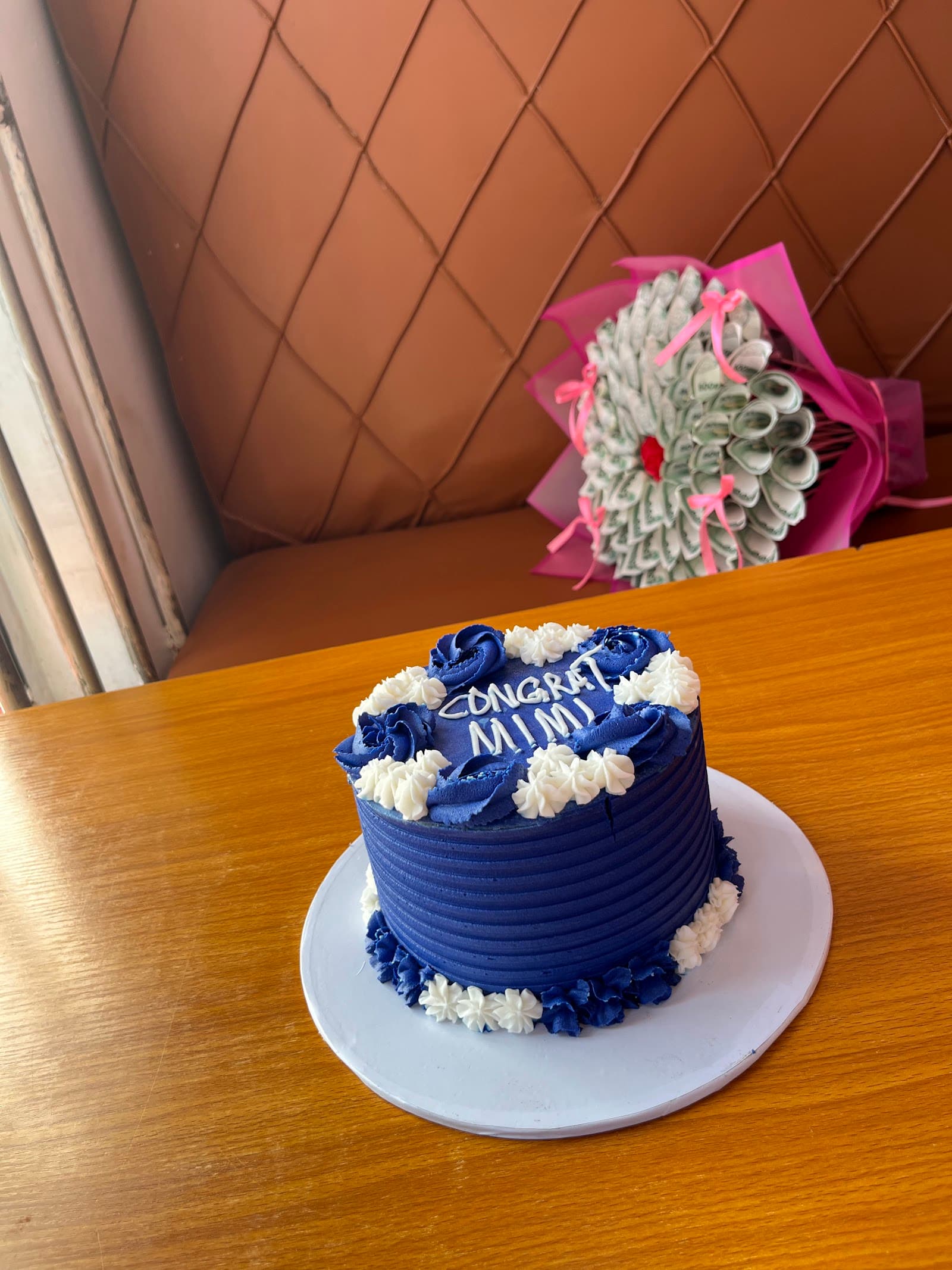 Navy blue congratulations cake with white rosettes