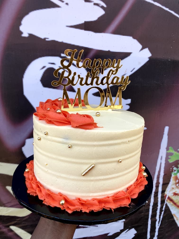 White birthday cake with red ruffles and a Happy Birthday Mom topper
